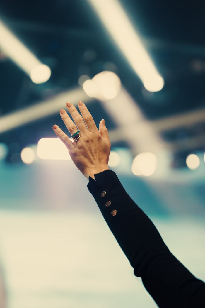 Crafting Captivating Headlines: Your awesome post title goes here A solitary hand reaches up in a well-lit room, possibly symbolizing connection or participation.